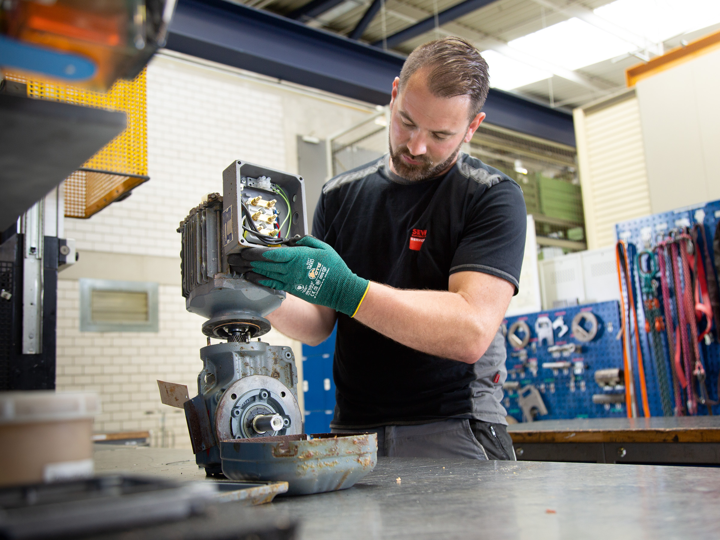 An SEW‑EURODRIVE employee carrying out repair work
