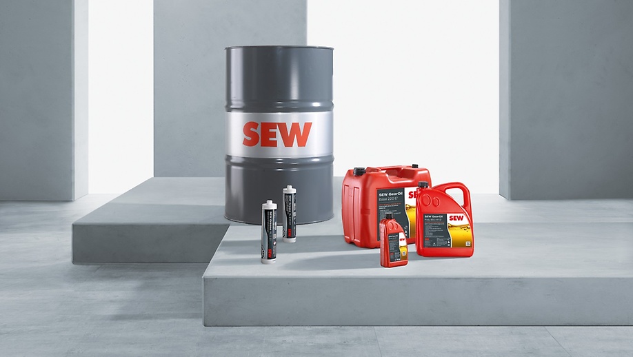 Gray oil barrel, two red oil canisters and two lubricant cartridges against a gray concrete background